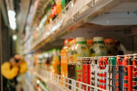 A vibrant array of assorted drinks displayed on shelves in a grocery store setting. Perfect for retail imagery.